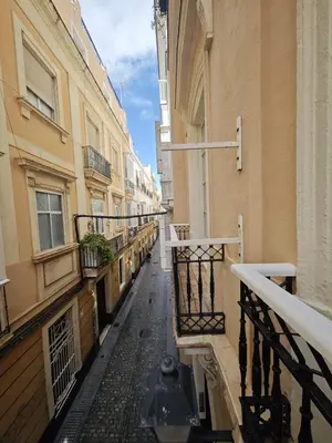 an empty alley between two buildings with a balcony at El Rincón de Ro Little Apartments in Cádiz