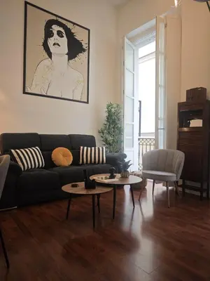 a living room with a couch and two tables at El Rincón de Ro Little Apartments in Cádiz