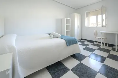a bedroom with a bed and a checkered floor at Apartamento Martínez Campos - Playa La Caleta in Cádiz