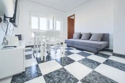 a living room with a couch and a checkered floor at Apartamento Martínez Campos - Playa La Caleta in Cádiz