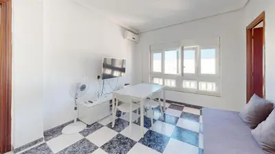 a white room with a desk and a window at Apartamento Martínez Campos - Playa La Caleta in Cádiz