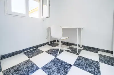 a desk and chair in a room with a checkered floor at Apartamento Martínez Campos - Playa La Caleta in Cádiz