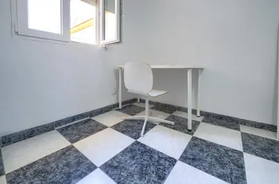 a desk and a chair in a room with a checkered floor at Apartamento Martínez Campos - Playa La Caleta in Cádiz