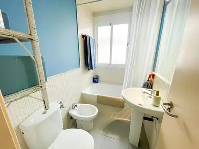 a bathroom with a white toilet and a sink at Encantador apartamento in Sanlúcar de Barrameda