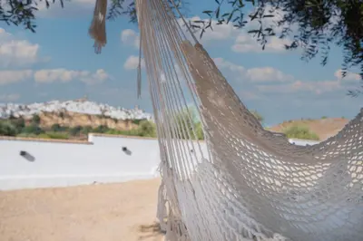 a hammock on a beach with buildings in the background at Mirador de la Peña in Arcos de la Frontera