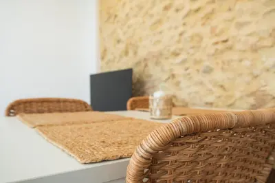 a dining room table with a wicker chair and a table and chairsuggest at Mirador de la Peña in Arcos de la Frontera