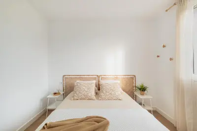 a white bedroom with a bed with two tables at Mirador de la Peña in Arcos de la Frontera