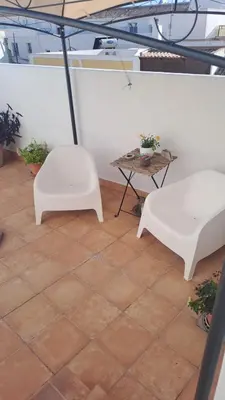 two white chairs and a table in a room at Alojamiento Rosalía in Sanlúcar de Barrameda