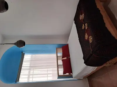 a room with a bed and a window at Alojamiento Rosalía in Sanlúcar de Barrameda
