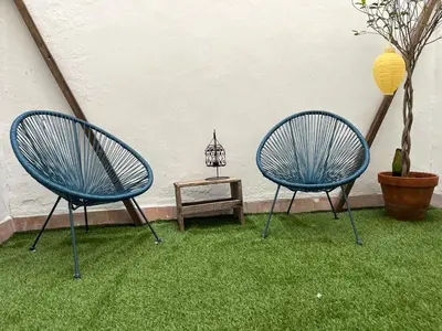 two blue chairs sitting on the grass with a table at nr15 in the heart of Cadiz in Cádiz