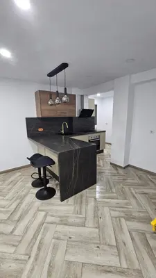 a kitchen with a black counter and a wooden floor at Apartamento el tejar in El Puerto de Santa María