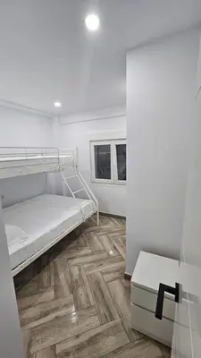 a room with a bunk bed and a wooden floor at Apartamento el tejar in El Puerto de Santa María