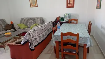 a living room with a table and chairs and a table and a couch at Apartamento económico verano 3 DORMITORIOS in El Trocadero