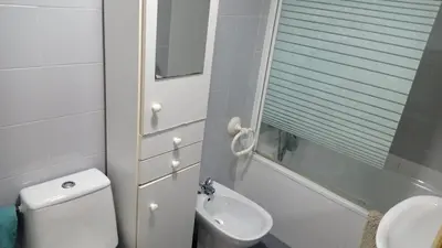 a white bathroom with a toilet and a sink at Apartamento económico verano 3 DORMITORIOS in El Trocadero