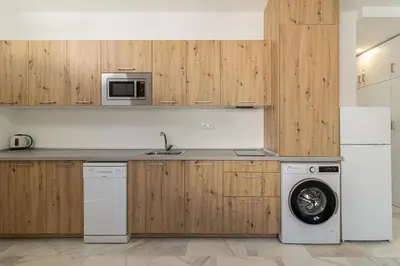 a kitchen with wooden cabinets and a washing machine at Jerez Centro Stay in Jerez de la Frontera