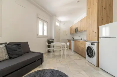a living room with a couch and a kitchen at Jerez Centro Stay in Jerez de la Frontera