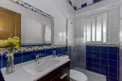 a bathroom with a sink and a toilet and a mirror at Turivivienda La Goleta in Conil de la Frontera