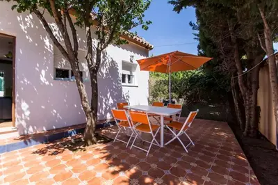 a table and chairs with an umbrella on a patio at Turivivienda La Goleta in Conil de la Frontera