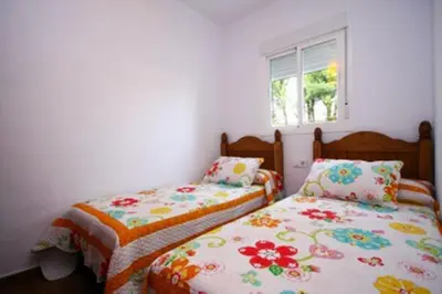 a bedroom with two beds and a window at Turivivienda La Goleta in Conil de la Frontera