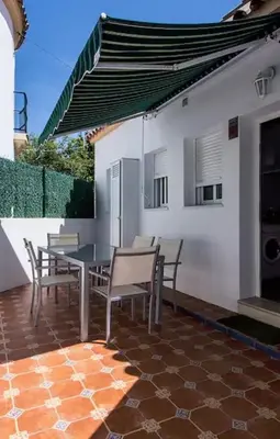 a patio with a table and chairs and a building at Turivivienda La Goleta in Conil de la Frontera