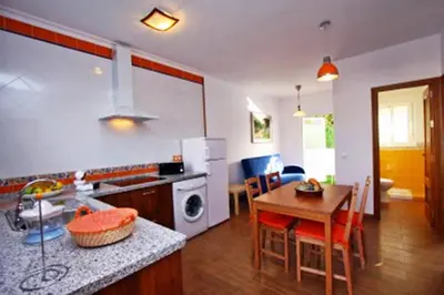 a kitchen and dining room with a table and a dining room at Turivivienda La Goleta in Conil de la Frontera