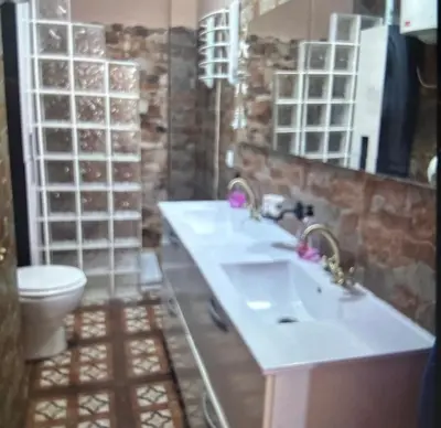 a bathroom with two sinks and a toilet at Piso en el centro de sanlucar Bda in Sanlúcar de Barrameda