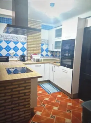 a kitchen with white cabinets and a tile floor at Piso en el centro de sanlucar Bda in Sanlúcar de Barrameda