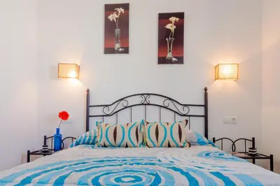 a bedroom with a bed with blue and white sheets at Casa Mariana in Conil de la Frontera