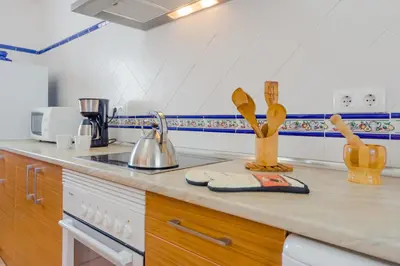 a kitchen with a counter top with wooden utensils at Casa Mariana in Conil de la Frontera