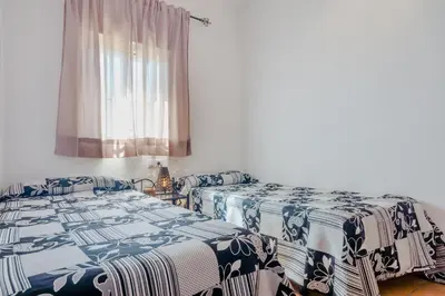 a bedroom with two beds and a window at Casa Mariana in Conil de la Frontera