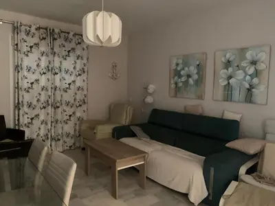 a living room with a green couch and a table at Apartamento Las Dunas Costa Ballena in Rota