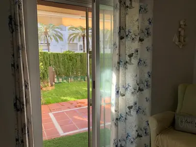 a sliding glass door with a view of a yard at Apartamento Las Dunas Costa Ballena in Rota