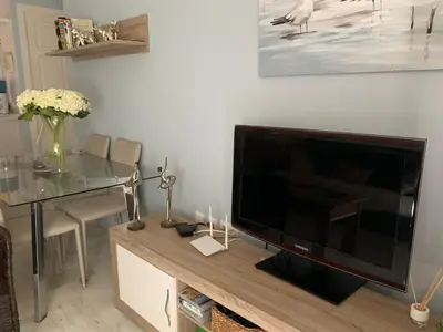 a living room with a large flat screen tv on a table at Apartamento Las Dunas Costa Ballena in Rota
