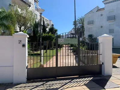 a gate with a sign in front of a building at Apartamento Las Dunas Costa Ballena in Rota