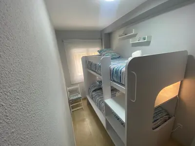 a small bedroom with a bunk bed in it at Apartamento Bahía de la Luz in Rota