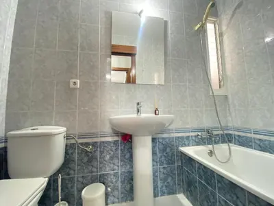 a bathroom with a white toilet and a sink at Apartamento Bahía de la Luz in Rota