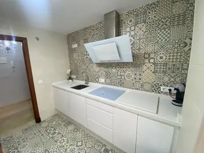 a kitchen with a sink and a tile wall at Apartamento Bahía de la Luz in Rota
