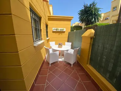 a patio with a white table and chairs on a building at Apartamento Bahía de la Luz in Rota