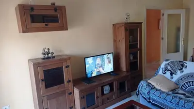 a living room with a television on a wooden entertainment center at Piso a buen precio con 3 HABITACIONES in Puerto Real