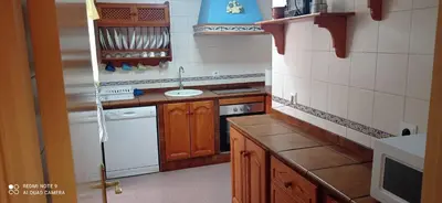 a small kitchen with wooden cabinets and a sink at Piso a buen precio con 3 HABITACIONES in Puerto Real