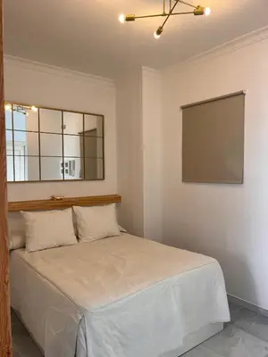 a bedroom with a bed with a mirror and a window at Estudio Cruz del Mar in Chipiona