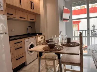 a kitchen with a table and a washing machine at Estudio Cruz del Mar in Chipiona