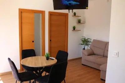 a living room with a table and chairs and a couch at La Barrosa Private Suites in Novo Sancti Petri