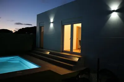a house with a swimming pool and a window at La Barrosa Private Suites in Novo Sancti Petri