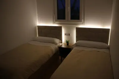two beds in a small room with a window at La Barrosa Private Suites in Novo Sancti Petri