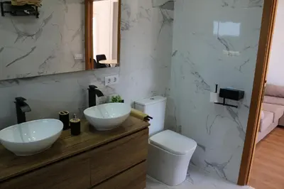 a bathroom with two sinks and a toilet at La Barrosa Private Suites in Novo Sancti Petri