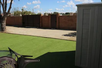 a yard with green grass and a fence at La Barrosa Private Suites in Novo Sancti Petri