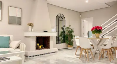 a living room with a fireplace and a table and chairs at Complejo Atlantico in Novo Sancti Petri