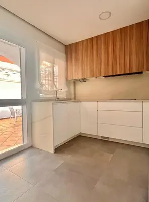 a kitchen with white cabinets and a large window at Complejo Atlantico in Novo Sancti Petri