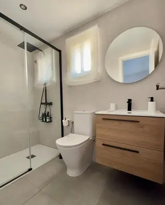 a bathroom with a toilet and a shower and a mirror at Complejo Atlantico in Novo Sancti Petri